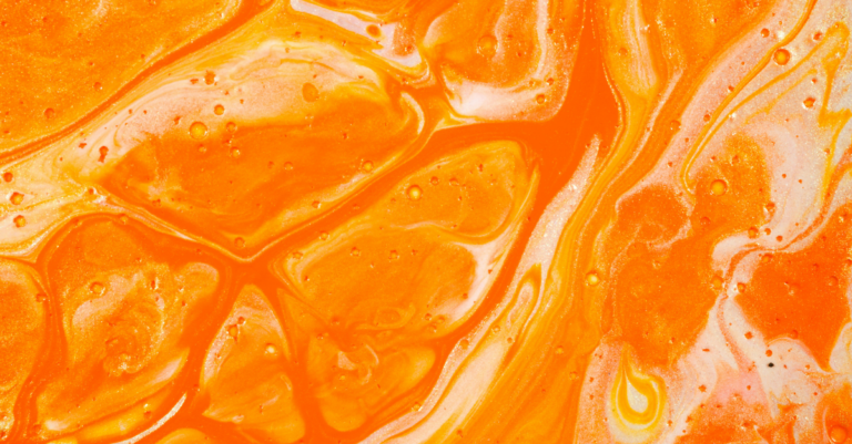 Close-up of bright orange marbled liquid with glossy swirls and white highlights.
