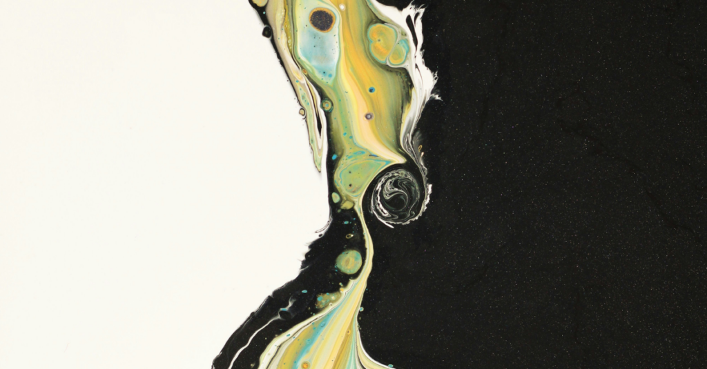 Abstract marbled edge where a jagged boundary divides cream on the left from black on the right, with yellow, green, and blue swirls along the border.